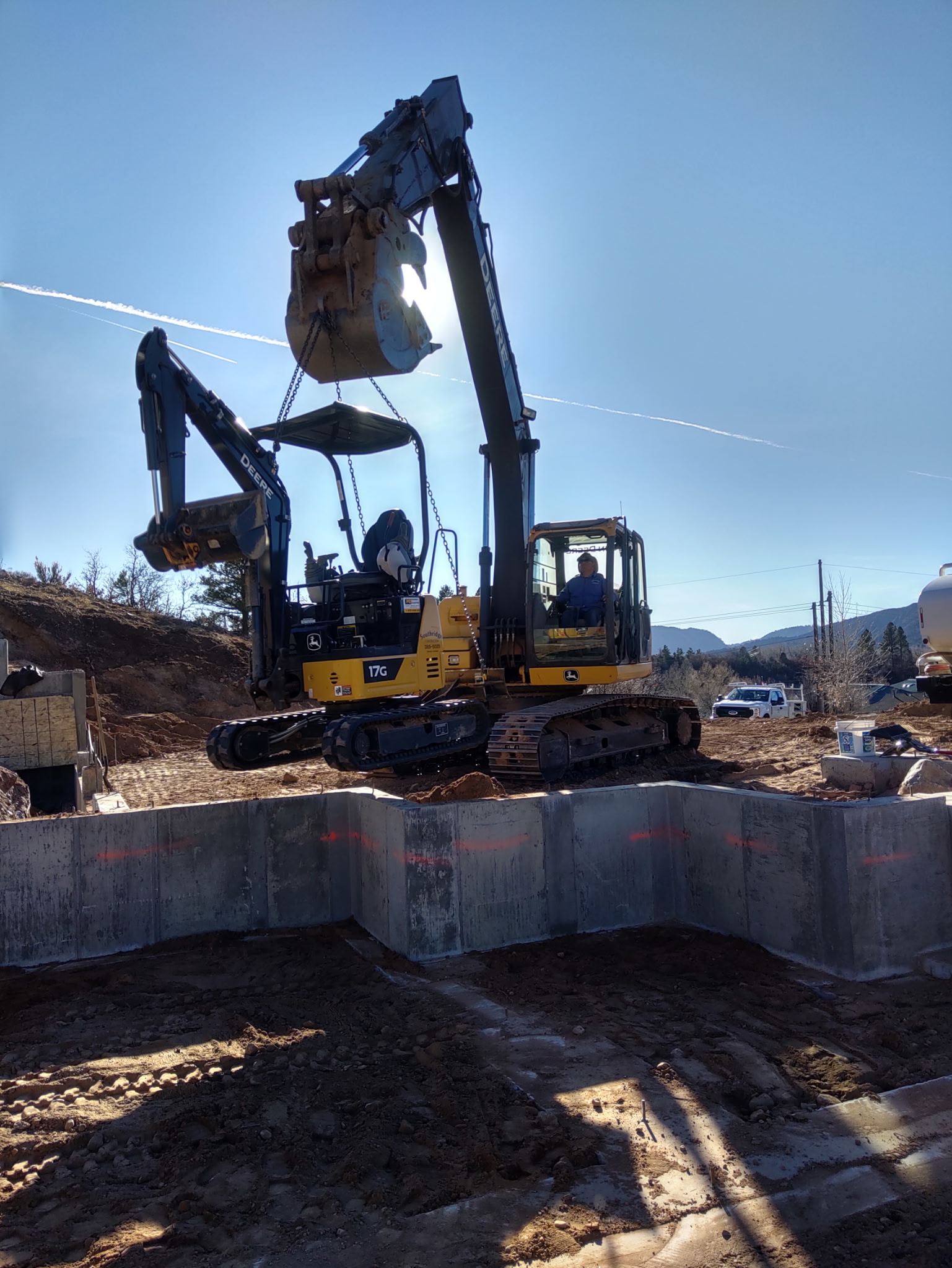 Large excavator picking up the mini excavator